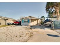 Quaint single-story home featuring a gravel driveway, carport, and partial stone facade at 6821 Sanderling Ln, Hudson, FL 34667