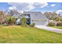Charming two-story home with a well-manicured lawn, lush landscaping and a two-car garage at 7892 S Leewynn Pl, Sarasota, FL 34240