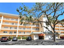 Multi-story condo building with balconies, parking, and manicured landscaping and attractive entryway at 8635 Midnight Pass Rd # 206C, Sarasota, FL 34242