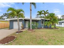 Charming single-story home with well-maintained lawn and tropical landscaping at 1604 Edna Ave, Largo, FL 33770