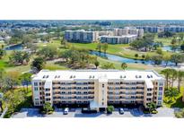 A beautiful multi-story condo building overlooks a lush golf course and serene water feature, creating an idyllic living environment at 3750 Pinebrook Circle # Apt 505, Bradenton, FL 34209