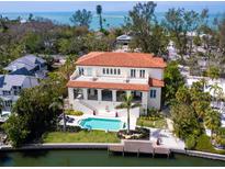 Aerial view of a coastal home with a pool and dock, nestled among mature trees at 4205 Higel Ave, Sarasota, FL 34242