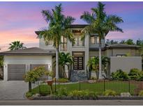 Stunning two-story home showcasing a meticulously landscaped front yard and modern architectural design at 4940 Peaceable Way, Sarasota, FL 34242