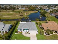 Aerial view of home on golf course with mature landscaping and waterfront views with pool and screened enclosure at 6 Bunker Cir, Rotonda West, FL 33947