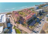 Stunning aerial view of the beachside condo complex with lush landscaping and beachfront access at 8710 Midnight Pass Rd # 501B, Sarasota, FL 34242