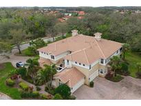 Stunning aerial view of home with tile roof, lush landscaping, and brick driveway at 9460 Discovery Ter # 202D, Bradenton, FL 34212
