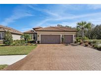 Beautiful single-story home featuring a clay tile roof, two-car garage and paver driveway at 10802 Seasons Way, Palmetto, FL 34221