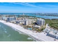 Stunning aerial view showcasing beachfront condos, pristine white sands, and turquoise waters on a sunny day at 1300 Benjamin Franklin Dr # 304, Sarasota, FL 34236