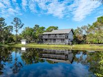 Waterfront property features a three-story home with wrap-around balconies reflected in the calm waters at 1471 Arcadia Ave, Sarasota, FL 34232