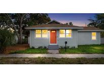 Charming single-story home featuring a light-blue facade, orange front door and well-manicured landscaping at 1739 16Th S Ave, St Petersburg, FL 33712