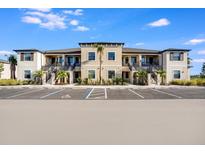 Beautiful exterior view of a multi-Gathering residence with lush landscaping and a spacious parking area at 23445 Collina Way # 10103, Port Charlotte, FL 33980