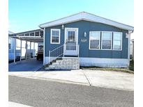Charming blue single-Gathering home featuring a carport, well-maintained landscaping, and a welcoming entrance at 3333 26Th E Ave # 1220, Bradenton, FL 34208