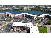 An aerial view of the condo community with multiple buildings, parking, and a waterfront view of the lake at 4133 Heron Way # E202, Bradenton, FL 34205