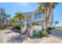 Inviting coastal home showcasing a brick stairway and lush landscaping at 44 Tidy Island Blvd, Bradenton, FL 34210
