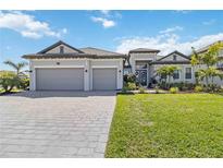 Beautifully landscaped single-Gathering home with a three-car garage and a paver driveway at 4856 Coastal Days Ln, Bradenton, FL 34211