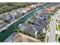 Stunning aerial view of waterfront property featuring a private pool, boat dock, and lush tropical landscaping at 581 Mast Dr, Bradenton, FL 34208