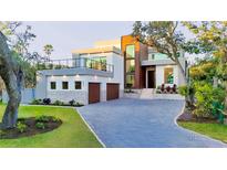 Contemporary two-story home with a private balcony, two-car garage, and a driveway leading to a welcoming front entrance at 603 Tremont St, Sarasota, FL 34242