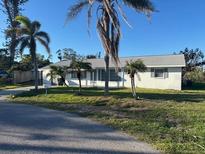 Charming single-story home with well-maintained lawn and mature palm trees, offering great curb appeal at 704 Chippy Ln, Nokomis, FL 34275