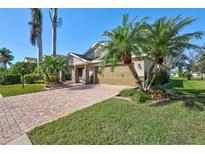 Charming home featuring a brick driveway, lush landscaping and mature palm trees, offering great curb appeal at 7214 35Th E Ln, Sarasota, FL 34243