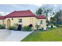 Charming home featuring a red tile roof, inviting landscaping, and well-maintained lawn at 916 W Faith Cir, Bradenton, FL 34212