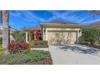 Charming single-story home with a well-manicured lawn, beautiful landscaping, and an attached two-car garage at 11812 Crawford Parrish Ln, Parrish, FL 34219