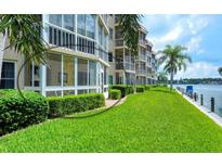 Waterfront condo with lush green lawn, landscaping and screened in lanai overlooking the water at 1350 N Portofino Dr # 108, Sarasota, FL 34242