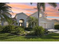 Stunning home exterior with a well-manicured lawn and lush tropical landscaping in a quiet neighborhood at 1655 Pinyon Pine Dr, Sarasota, FL 34240