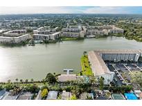 This aerial view captures a lakeside community with multiple buildings, a lake, and a parking lot at 3424 Lake Bayshore Dr # 405, Bradenton, FL 34205