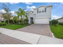 Charming two-story home with a well-manicured lawn, brick driveway, and beautiful landscaping at 3442 Chestertown Loop, Bradenton, FL 34211