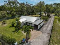An aerial view of a charming home boasting lush landscaping, mature trees and a long driveway at 4116 34Th E Ave, Bradenton, FL 34208