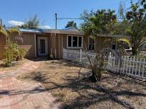 Charming single story home featuring mature trees, a white picket fence and quaint brick walkway at 4725 Gleason Ave, Sarasota, FL 34242