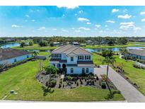 Stunning aerial view of a two-story home with tile roof, landscaped yard, and serene lake views at 4789 Vasca Dr, Sarasota, FL 34240