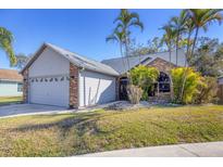 Charming single-story home with mature palm trees and a two-car garage at 5047 82Nd E Way, Sarasota, FL 34243