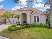 Charming single-story home with a tile roof, manicured lawn, and lush tropical landscaping at 5142 Cote Du Rhone Way, Sarasota, FL 34238