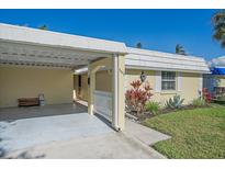 Charming single-story home featuring a carport, well-maintained landscaping, and a bright, welcoming facade at 5869 Tidewood Ave # 7, Sarasota, FL 34231