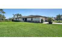 Well-maintained home exterior with a lush green lawn and manicured landscaping at 7347 Royal Birkdale Dr, Sarasota, FL 34238