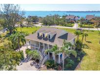 Beautiful coastal home with a large wrap-around porch, lush landscaping and scenic waterfront views at 92 Tidy Island Blvd, Bradenton, FL 34210