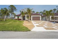 Beautiful single Gathering home with an attractive lawn, rock landscaping, and a decorative concrete driveway at 115 Solana St, North Port, FL 34287