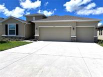 Beautiful home featuring a three-car garage and well-maintained landscaping at 13393 Golden Lime Ave, Spring Hill, FL 34609