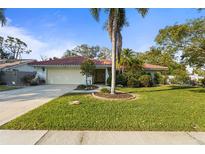Charming single-story home with a well-manicured lawn and a classic red tile roof at 1354 Lucaya Ave, Venice, FL 34285