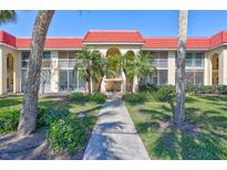 Attractive condo building with a red roof, beautiful palms, and meticulously maintained landscaping at 137 Avenida Messina # 3, Sarasota, FL 34242