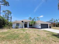 Charming single-story home with a well-manicured lawn and a two-car garage at 1402 Jakway Rd, North Port, FL 34288