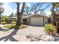 Charming exterior with a brick driveway and attached one car garage with beautiful lush landscaping at 1622 Wisconsin Ln, Sarasota, FL 34239