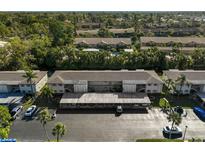 Aerial view of the condo building featuring covered parking and mature trees at 2851 Swifton Dr # 39, Sarasota, FL 34231