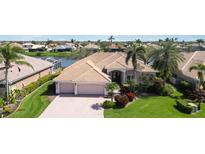 Waterfront single-story home featuring a three-car garage and tropical landscaping at 2879 Grazeland Dr, Sarasota, FL 34240