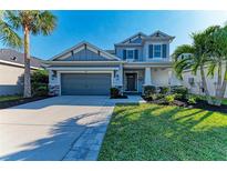 Two-story home with a gray facade, well-manicured lawn, and a two-car garage at 5709 Sunflower Cir, Sarasota, FL 34238