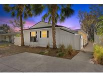 Charming exterior view of the home featuring tropical landscaping and a privacy fence at 6201 Waverly Rd, Weeki Wachee, FL 34607