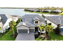 Stunning two-story home features a stone driveway, two-car garage, beautiful landscaping, and gorgeous water view at 7717 Mainsail Ln, Sarasota, FL 34240