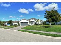 Charming single-story home with a well-manicured lawn and inviting curb appeal under a beautiful blue sky at 7744 Sandhill Lake Dr, Sarasota, FL 34241