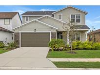Two story home featuring a two car garage and a well manicured lawn at 8330 Abalone Loop, Parrish, FL 34219
